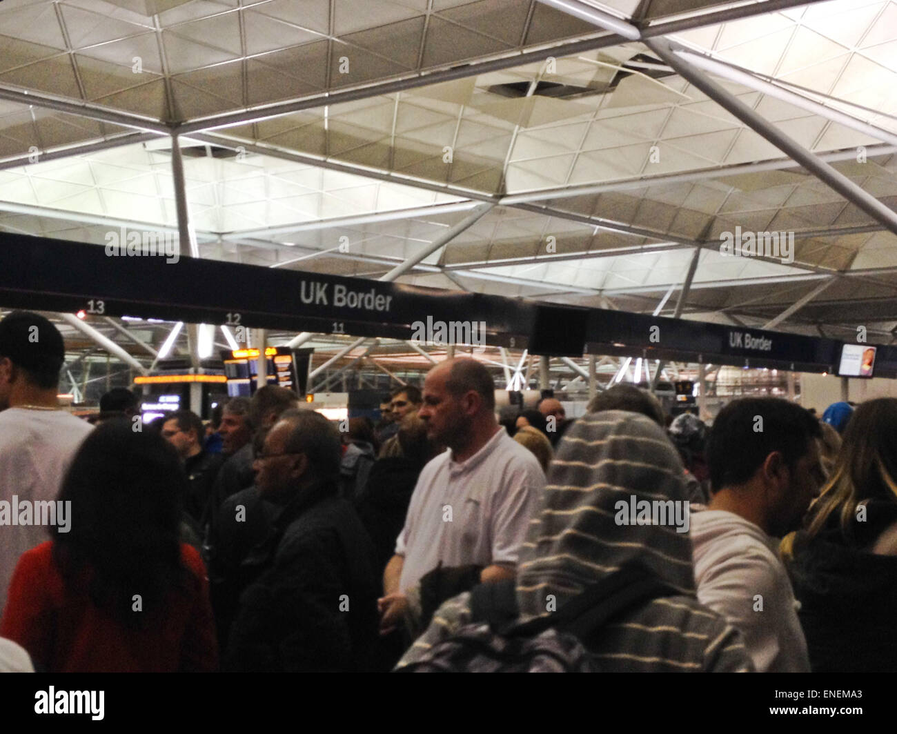 Stanstead, Regno Unito. Xxv Aprile 2015. Un folto gruppo di passeggeri in arrivo attendere al controllo passaporti. Foto Stock