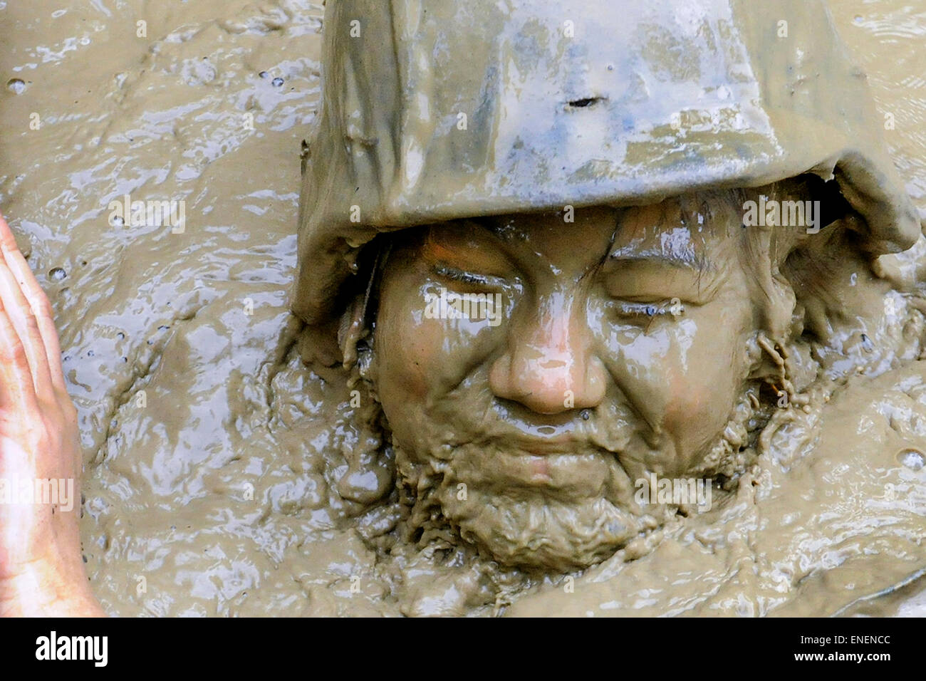 Un U.S. Navy sailor aprile Schwertman galleggianti attraverso il ristagno di acqua fangosa durante la giungla endurance in corso presso la Guerra nella Giungla Centro Training Camp Gonsalves Aprile 24, 2015 a Okinawa, Giappone. Foto Stock