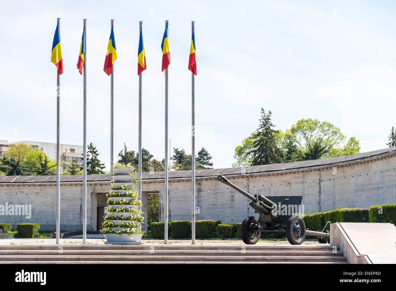 Il rumeno di bandiere e di guerra il cannone al mausoleo di eroi rumena a Bucarest Foto Stock