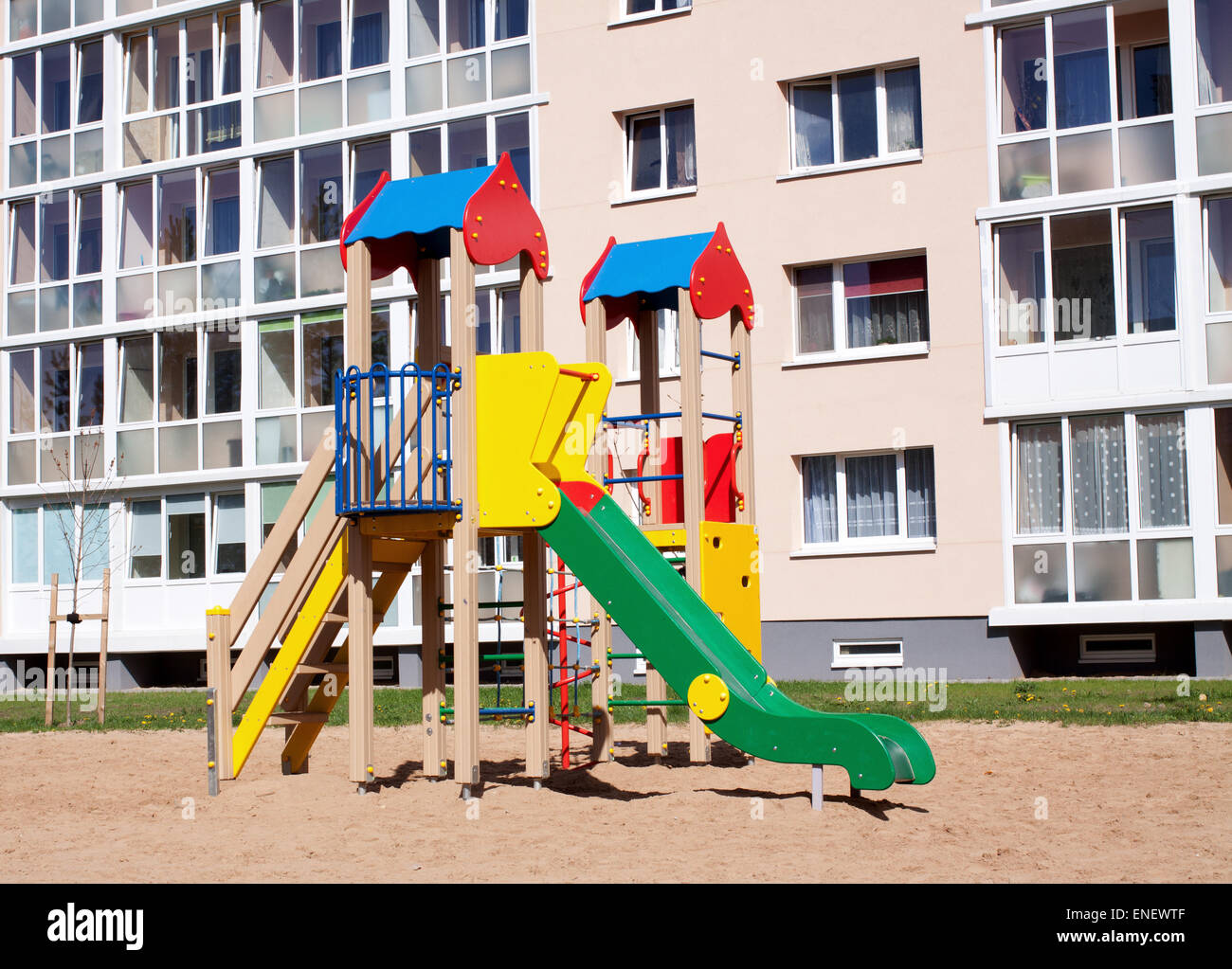 Colorato parco giochi per bambini in natura, anteriore della fila di nuova costruzione appartamenti di blocco Foto Stock