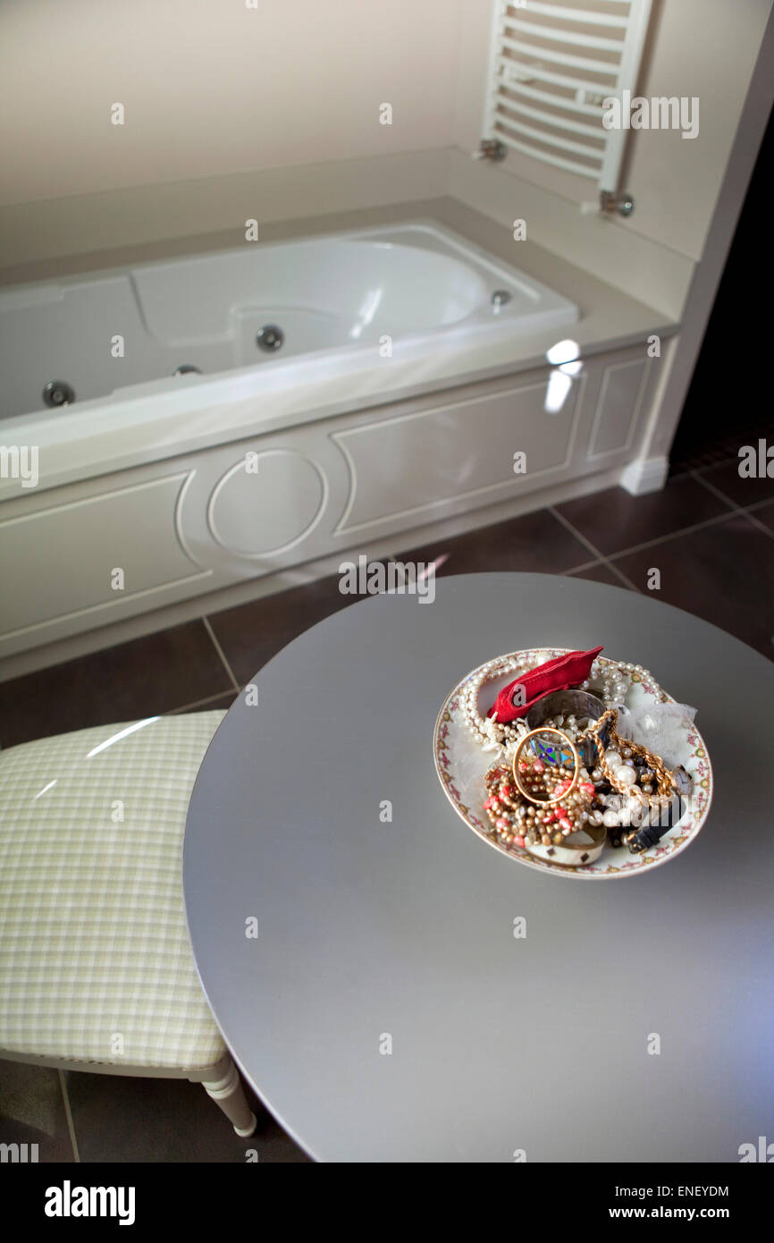 Costume jewelery su di una piastra in un bagno Foto Stock