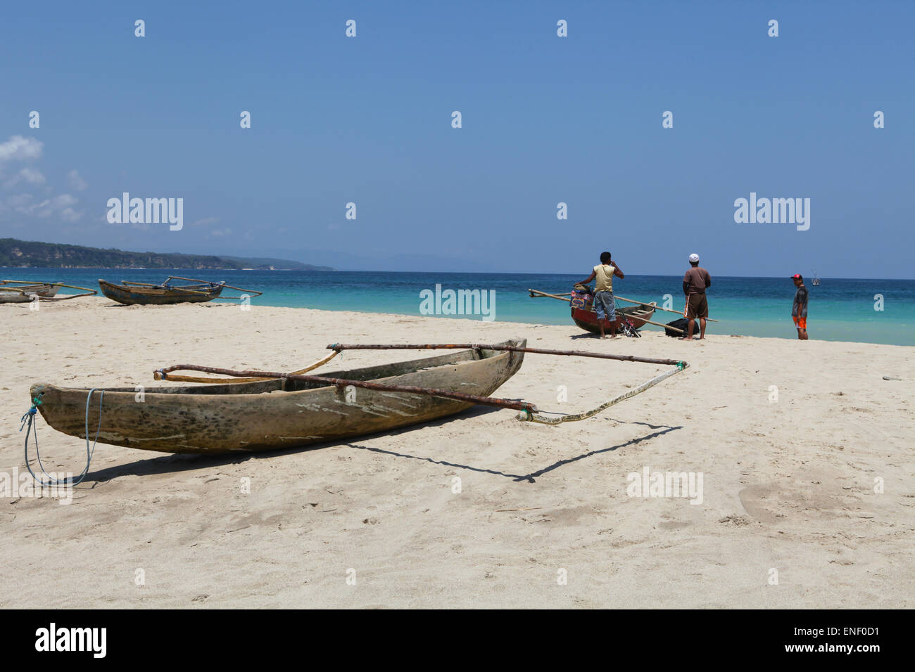 Pescatori e una canoa da pesca sulla spiaggia che si affaccia sull'Oceano Indiano, nel villaggio di Wanokaka a Sumba Island, West Sumba, East Nusa Tenggara, Indonesia. Foto Stock