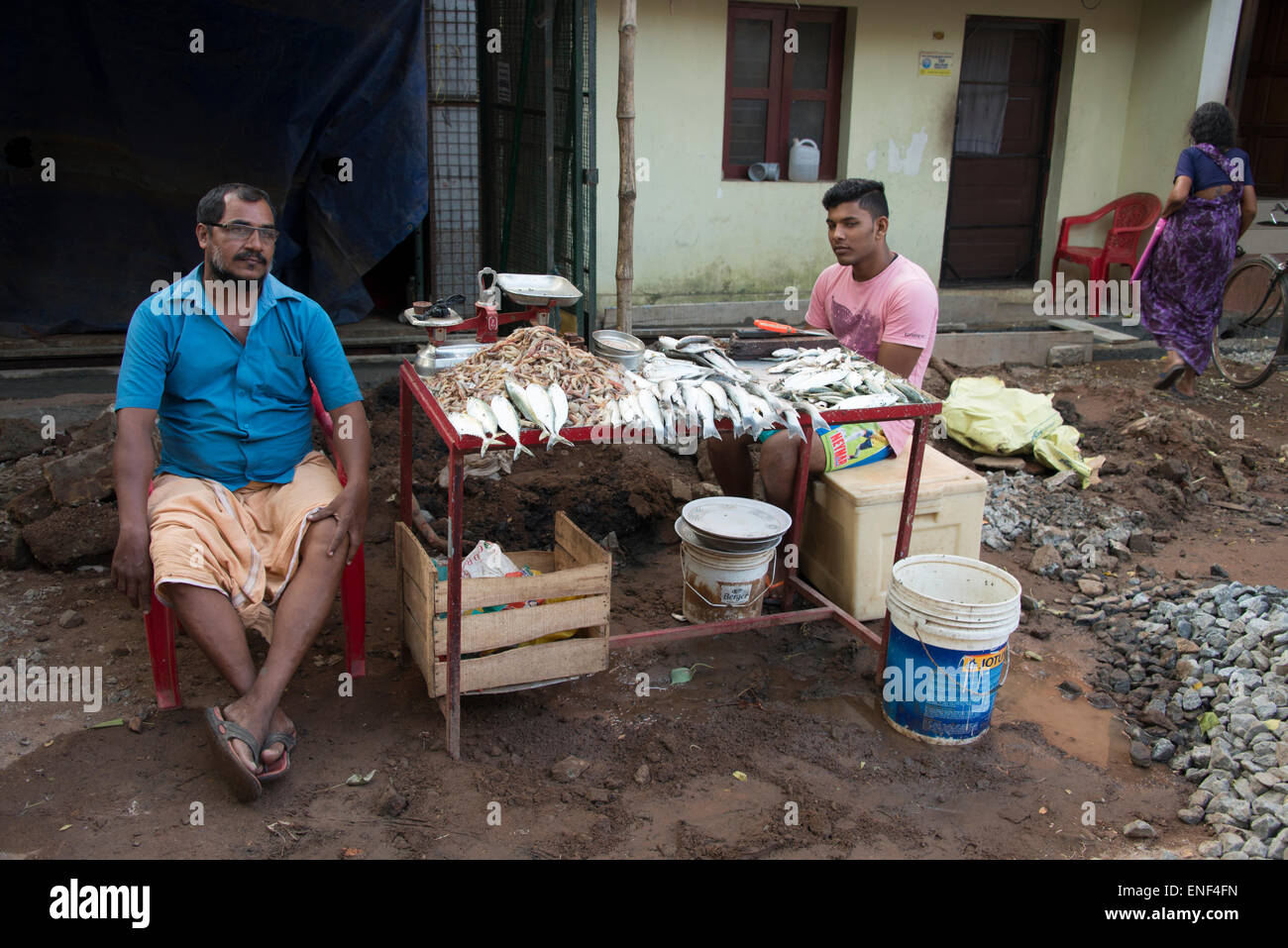 Due pescivendoli con il loro set-up store su una strada trafficata a Fort Cochin a Kochi, Kerala, India Foto Stock