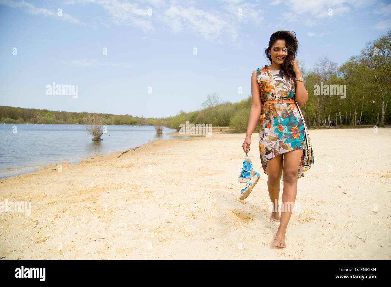 Giovane donna camminando lungo la riva del fiume Foto Stock