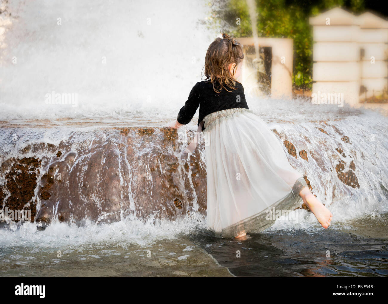 Bambina giocando in una fontana Foto Stock