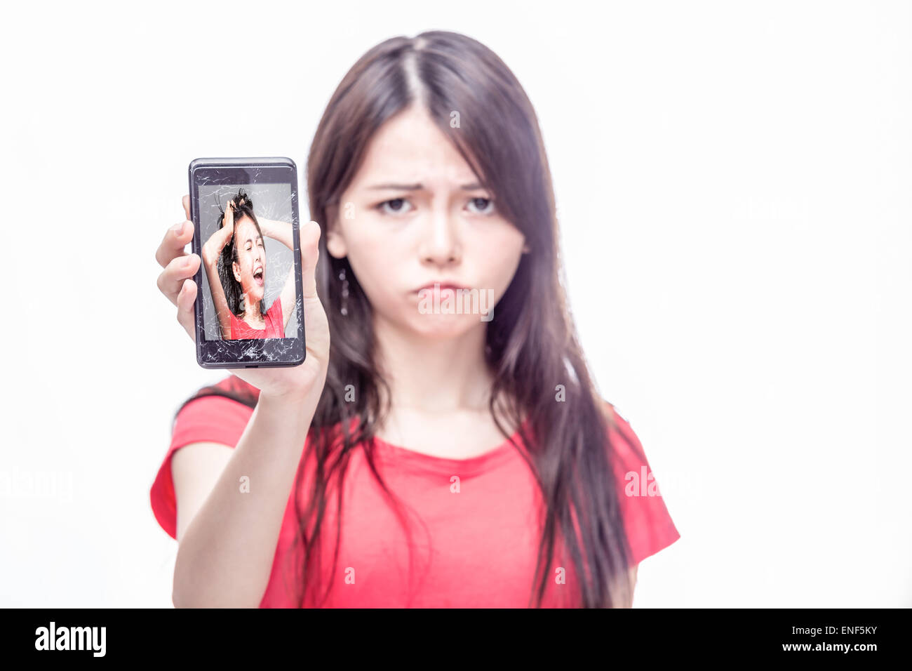 Sconvolto donna cinese, in prossimita', tenendo incrinato telefono cellulare con se stessa sullo schermo urlando, frustrazione, intrappolati concept Foto Stock