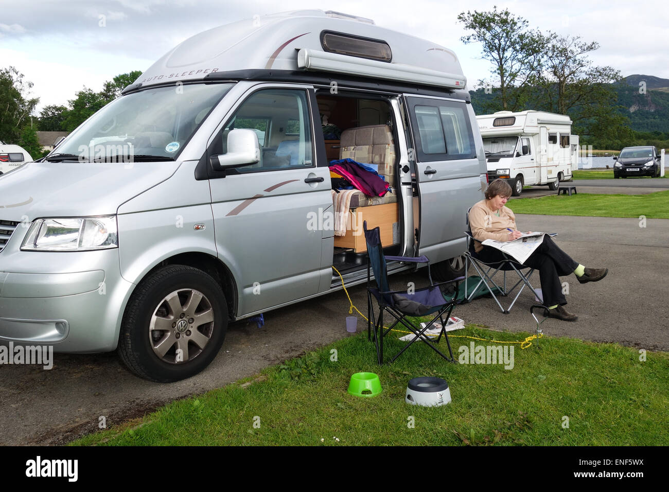 La lettura al di fuori di Motorcaravan, campeggio e caravaning Club sito, Keswick, Lake District, Cumbria Foto Stock