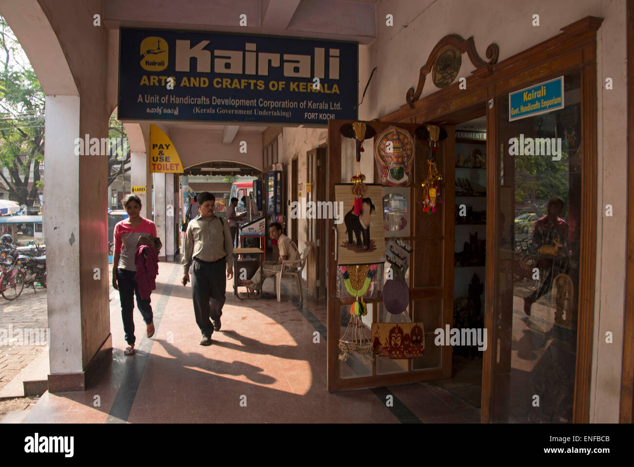 I turisti si avvicinano ad un negozio di souvenir di arti e artigianato del Kerala a Fort Cochin, Kochi, India Foto Stock
