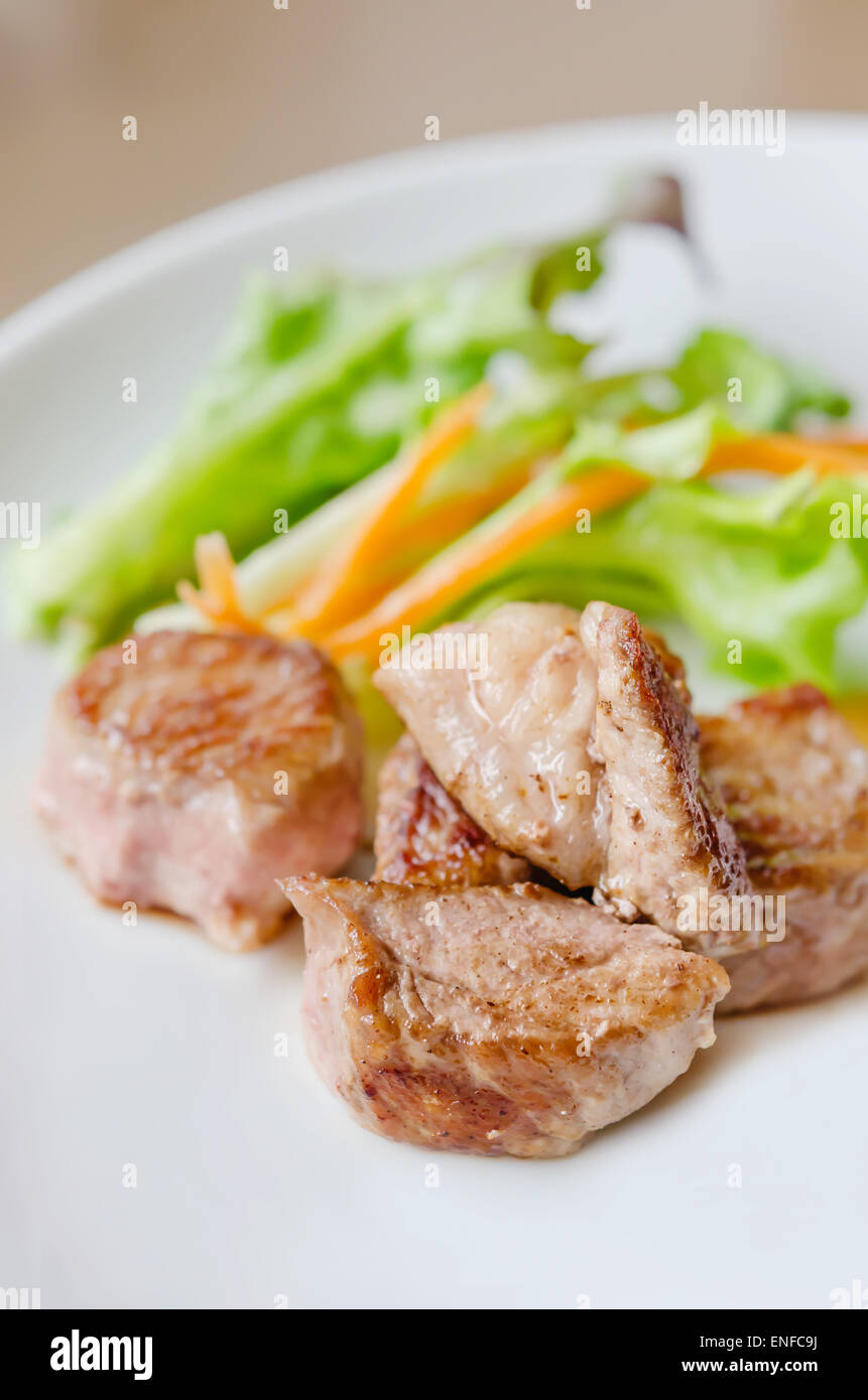 Grigliate di carne di maiale con insalata fresca su una piastra Foto Stock