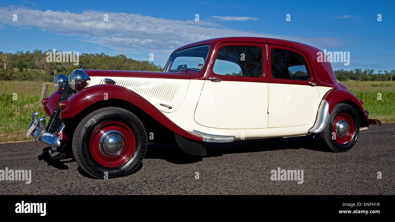 Citroen degli anni cinquanta big 15 classic car restaurata, con il rosso e crema e luccicanti alla vernice sulla strada accanto al campo di erba verde Foto Stock