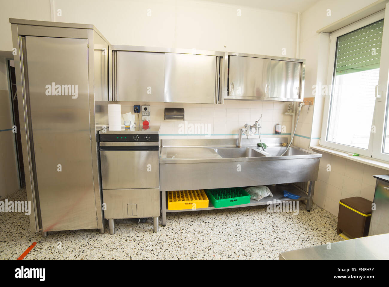 Grande cucina industriale con frigorifero, lavastoviglie e lavandino tutti  in acciaio inox Foto stock - Alamy