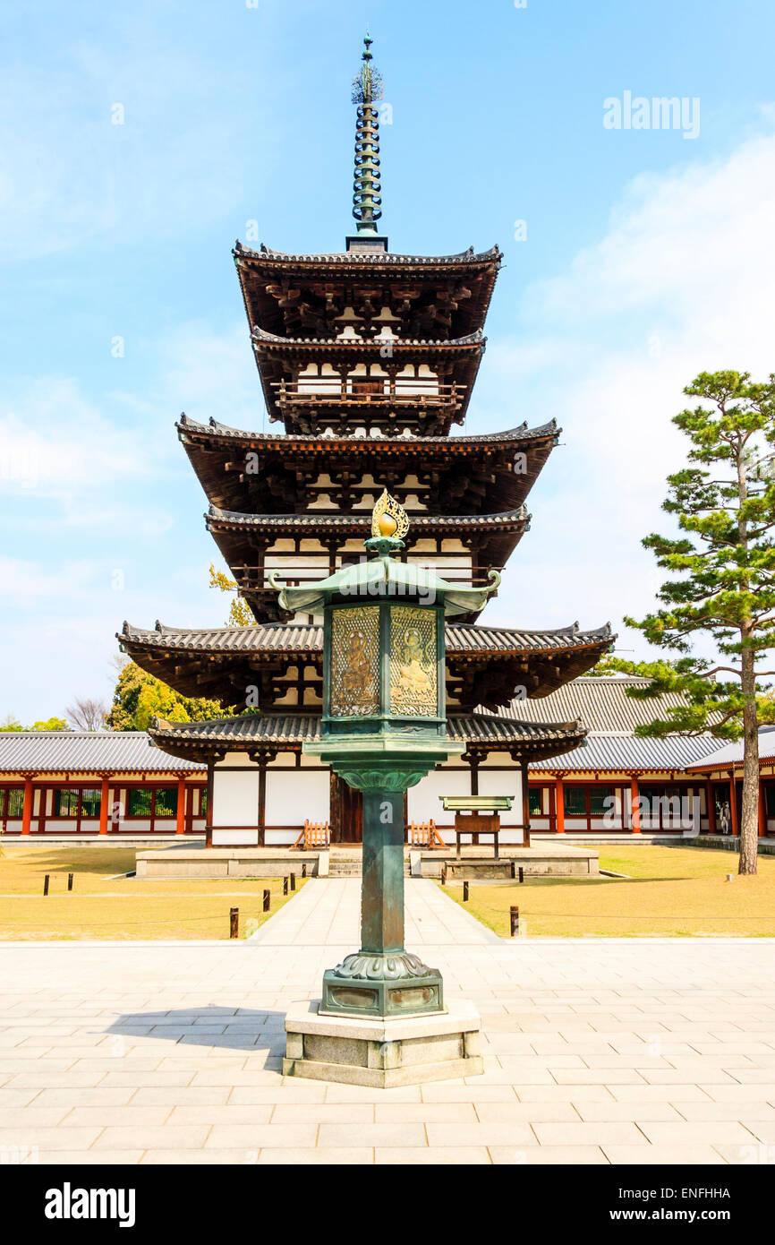 Giappone, Nara, tempio di Yakushiji. Lanterna di pietra e la pagoda orientale, Toto, risalente al XII secolo Hakuho periodo con sfondo di cielo blu. Foto Stock