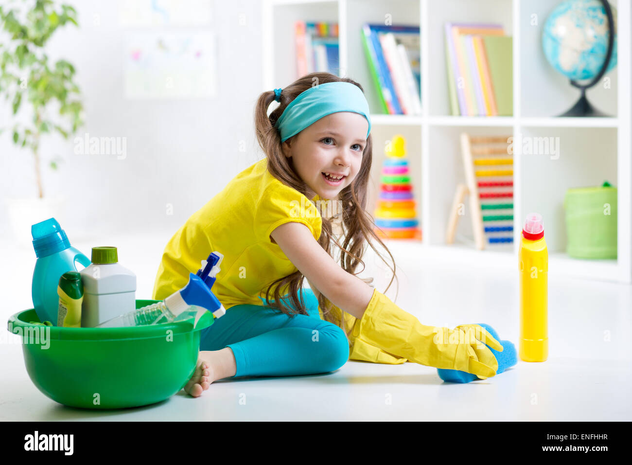 Carino kid bambina pulisce un pavimento in camera per bambini Foto Stock
