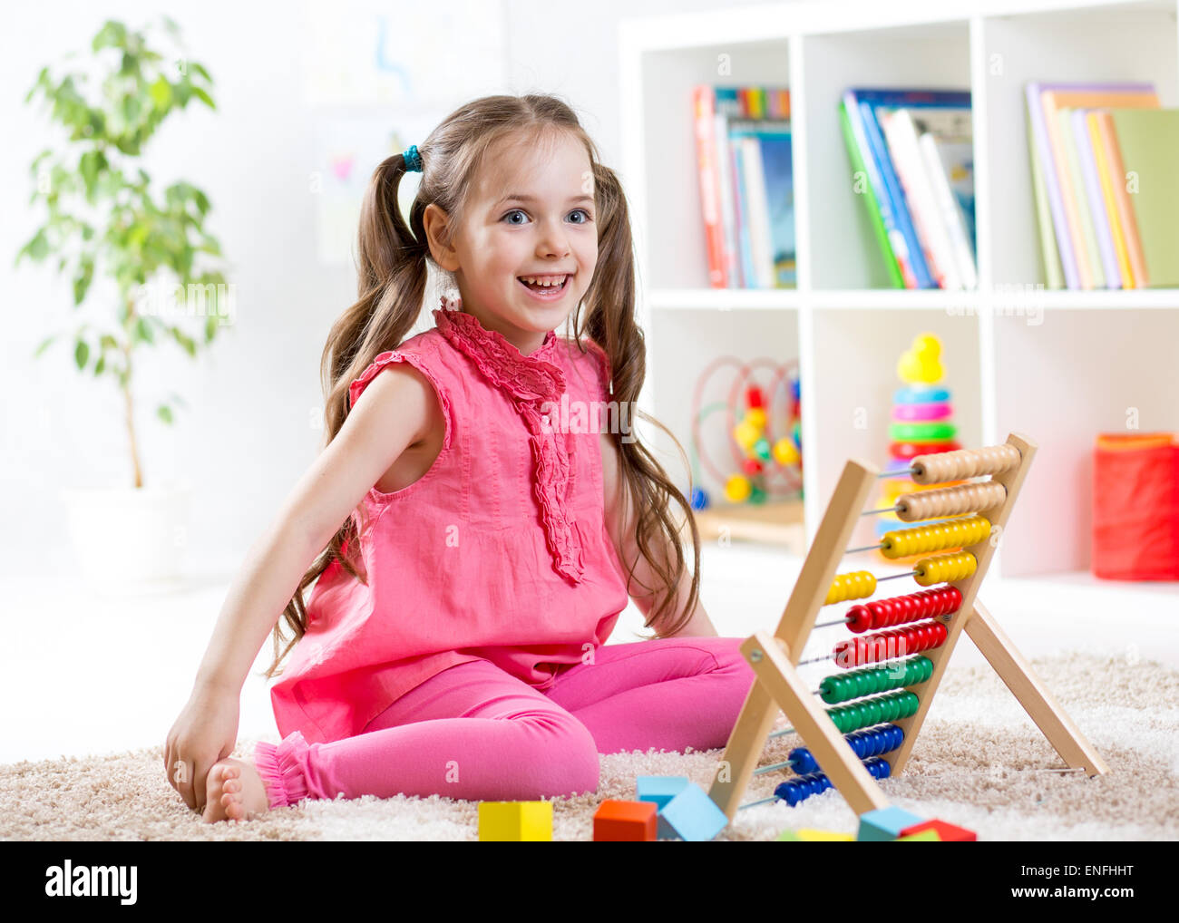 Capretto felice ragazza che gioca con abacus toy in ambienti interni Foto Stock