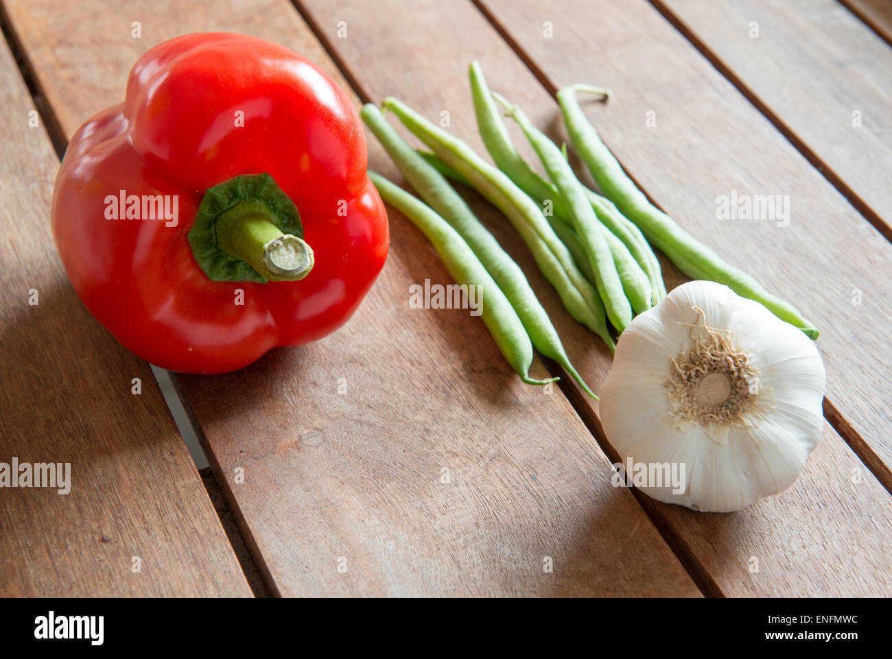 Red capsicum, fagioli verdi e aglio sul tavolo di legno Foto Stock Red capsicum, fagioli verdi e aglio sul tavolo di legno Foto Stock