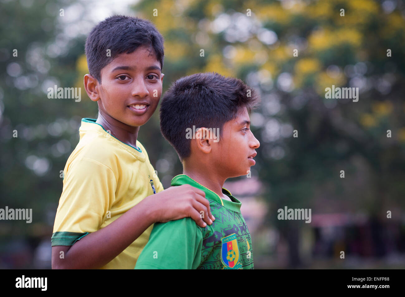 Due ragazzi durante una breve pausa in una partita di calcio, parata a terra, Fort Cochin, Kochi, Kerala, India Foto Stock