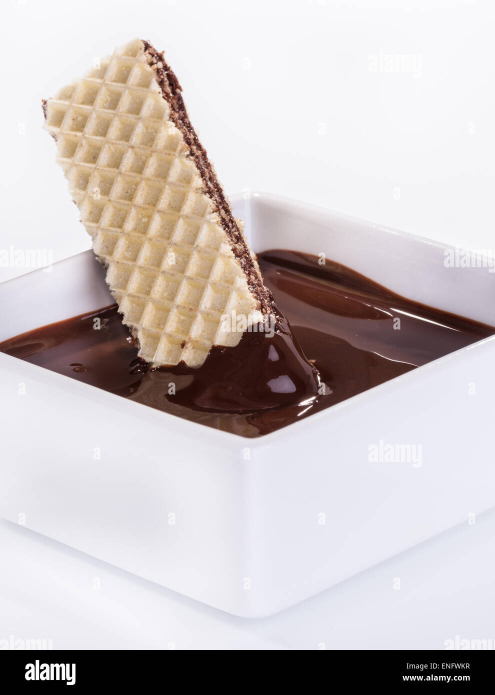 Salsa al cioccolato e un biscotto in una ciotola su un tavolo bianco Foto Stock