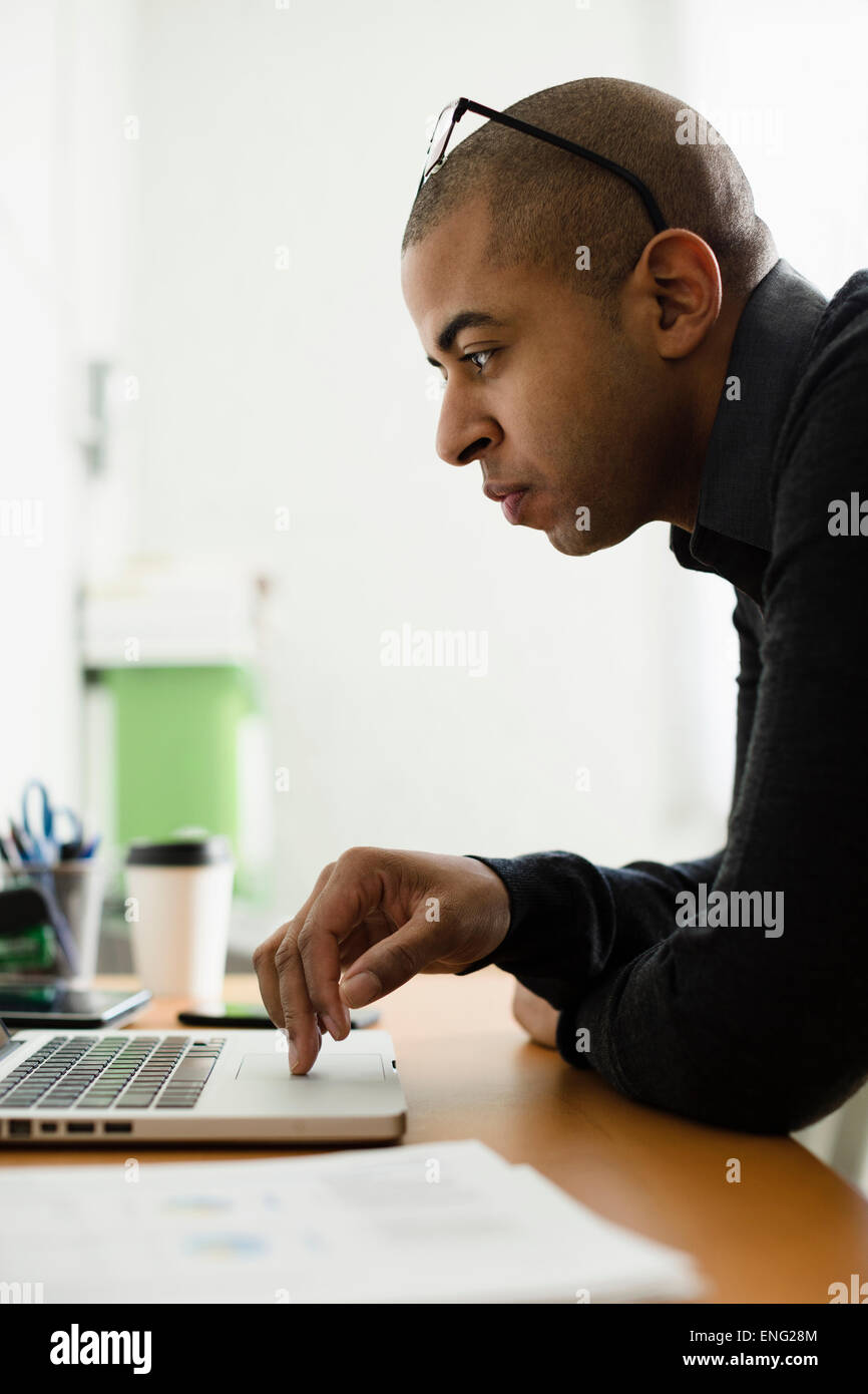 Razza mista imprenditore lavora su computer portatile alla reception Foto Stock
