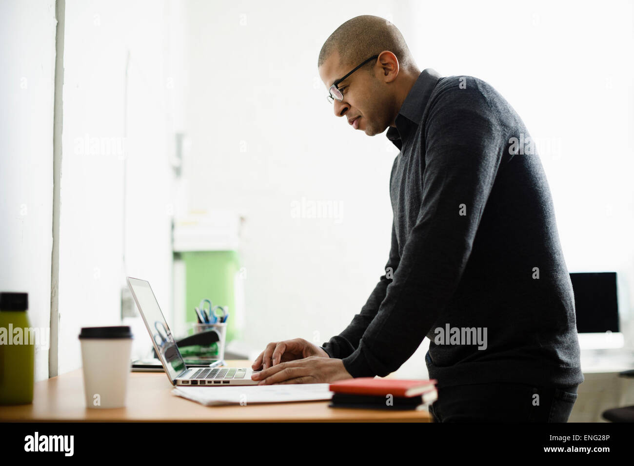 Razza mista imprenditore lavora su computer portatile alla reception Foto Stock