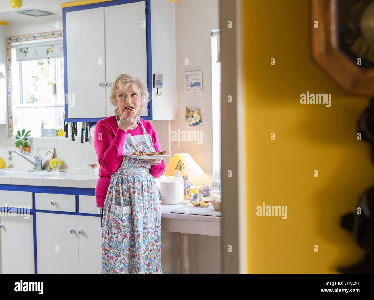 I vecchi donna caucasica dove mangiare in cucina Foto Stock