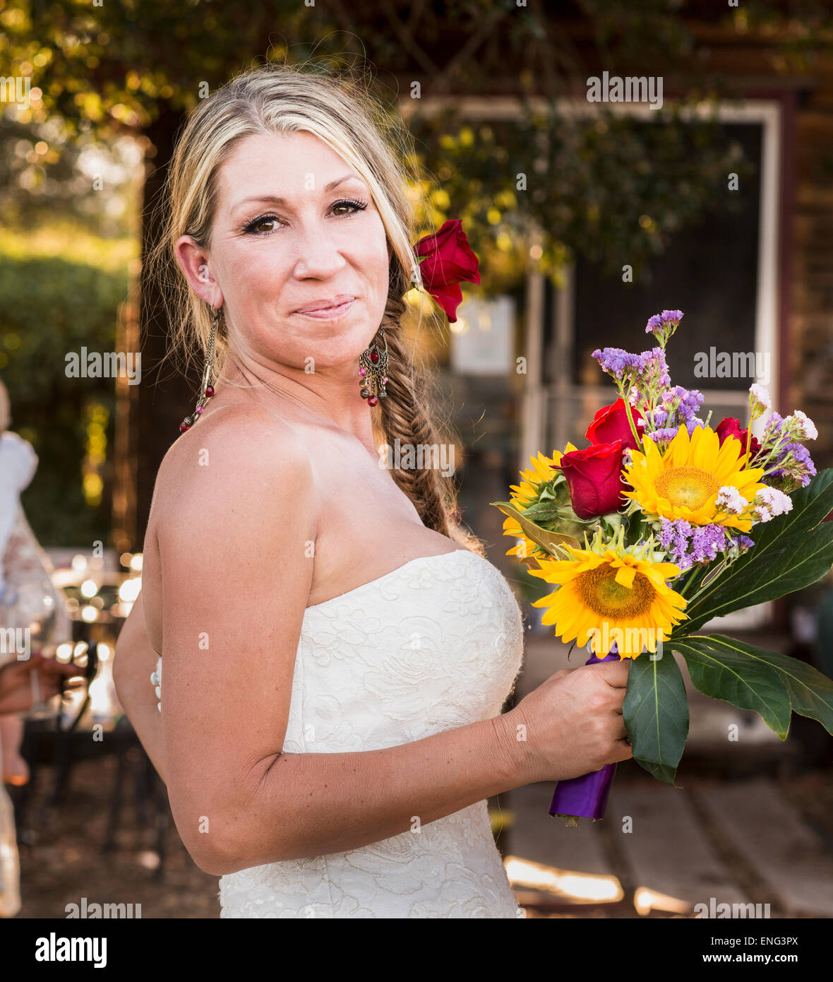 Sorridente sposa caucasica holding bouquet di fiori Foto Stock