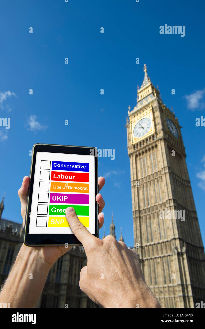 LONDON, Regno Unito - 27 Aprile 2015: British elettore seleziona da un elenco di partiti politici su una compressa di fronte il Palazzo di Westminster. Foto Stock