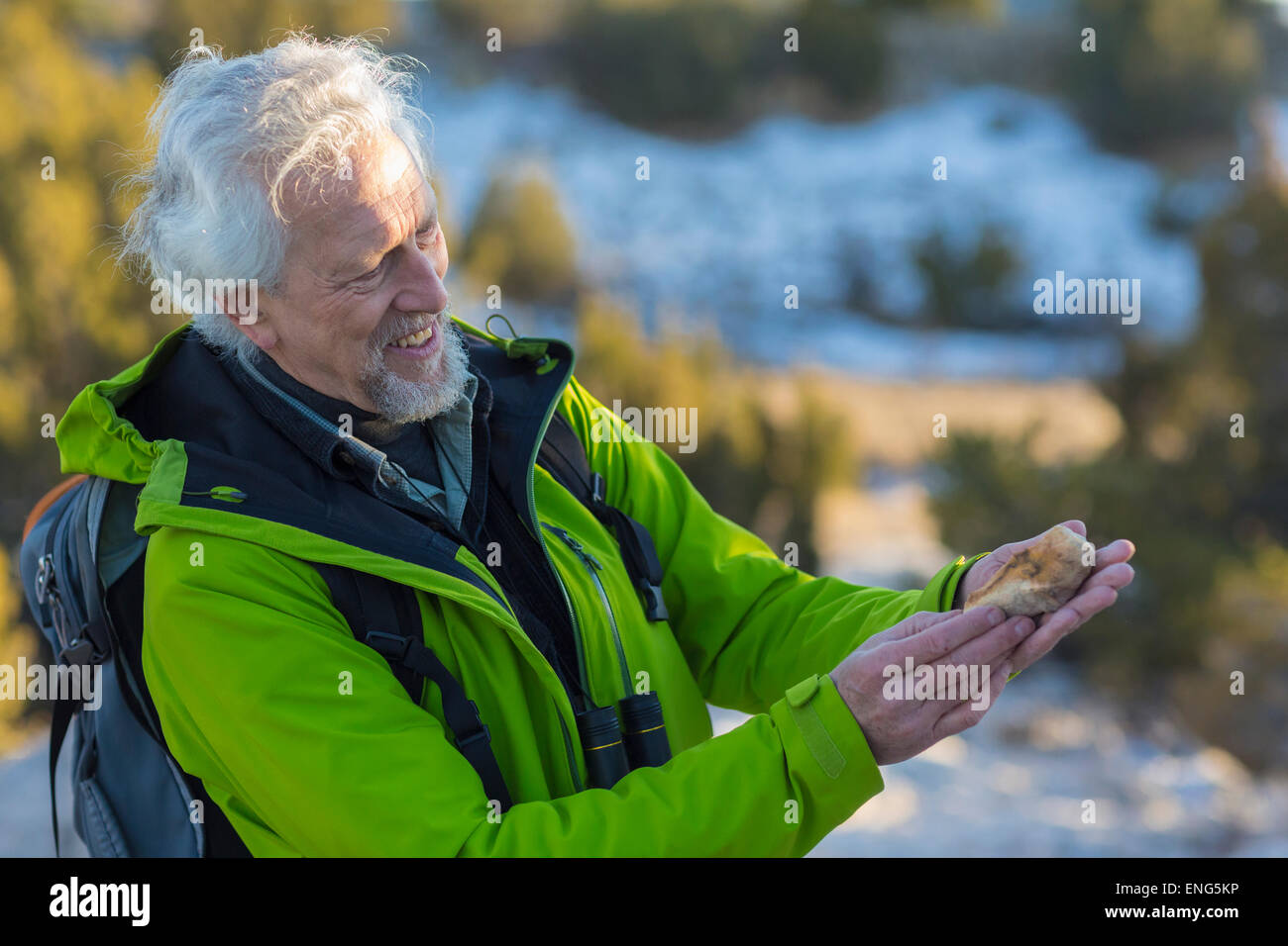Uomo vecchio ammirando roccia su escursione Foto Stock