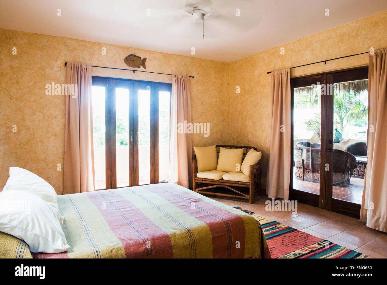 Porte a vetro, letto matrimoniale e divano a due posti in camera da letto Foto Stock