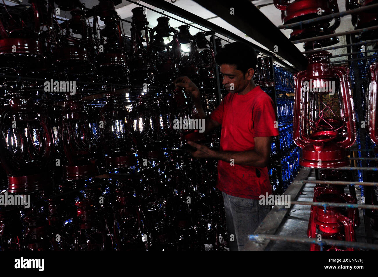 Un lavoro lavora in un uragano lanterna (olio lampada) fabbrica a kamrangyr char a Dhaka, nel Bangladesh. Giugno 6, 2013. Foto Stock