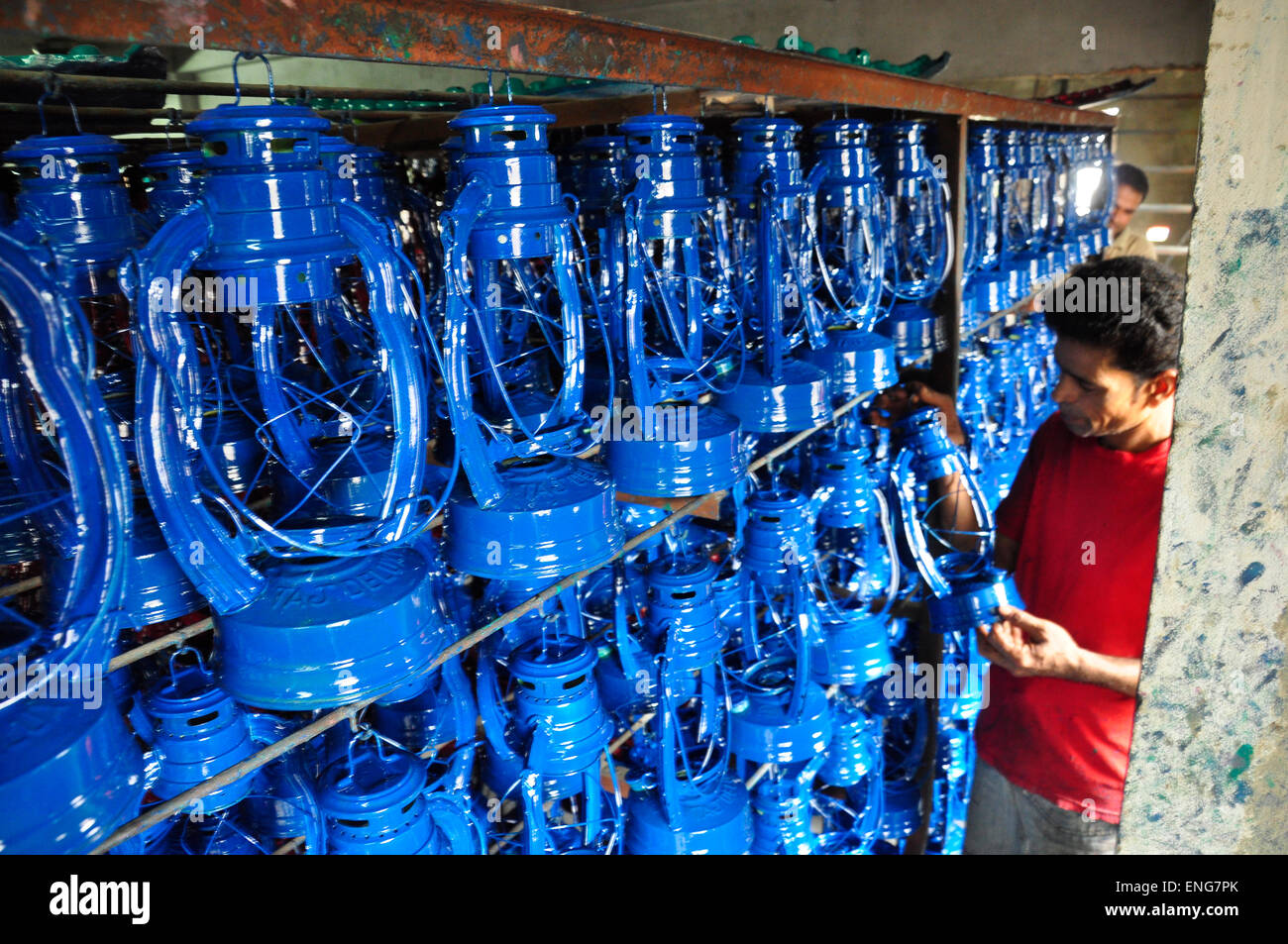 Un lavoro lavora in un uragano lanterna (olio lampada) fabbrica a kamrangyr char a Dhaka, nel Bangladesh. Giugno 6, 2013. Foto Stock