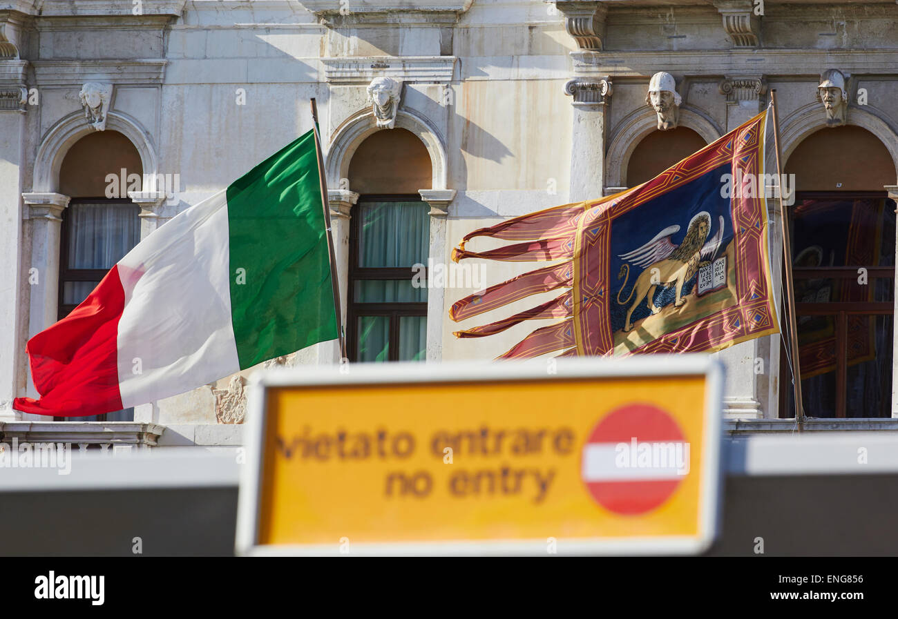 Focus sul veneziano e bandiere italiane battenti dietro un segnale di divieto di accesso in inglese e in Italiano Venezia Veneto Italia Europa Foto Stock