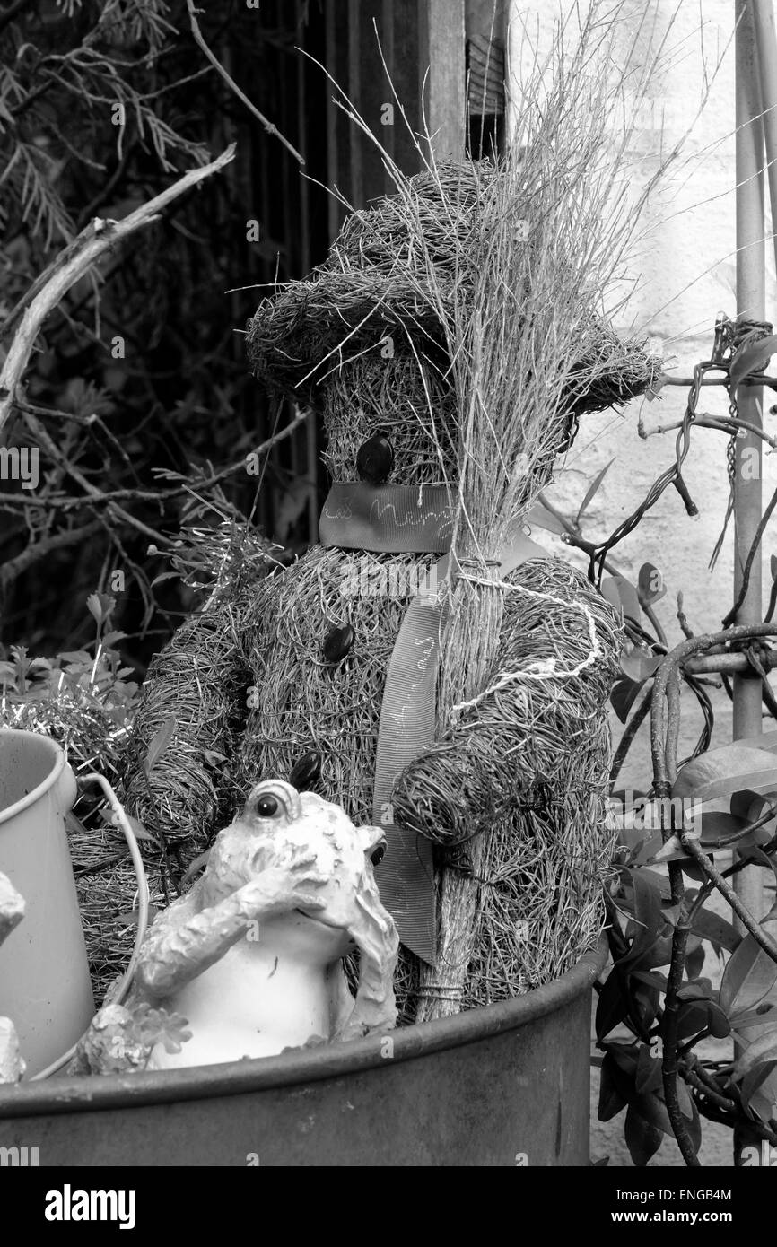 Orsacchiotto di peluche della paglia è usata come un ornamento del giardino in un vaso di fiori Foto Stock