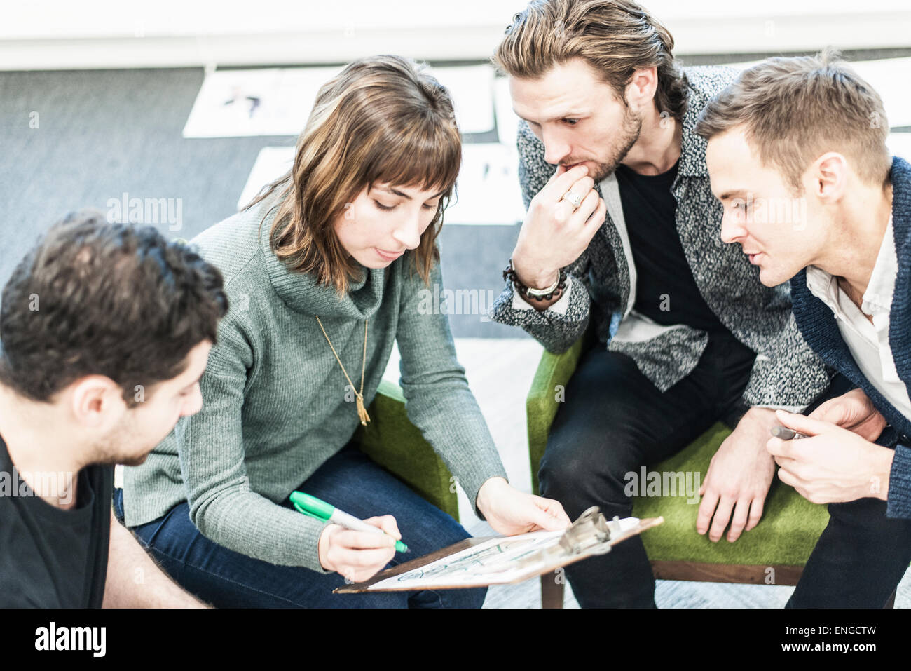 Quattro persone e colleghi nel corso di una riunione, e un uomo di scrivere con un pennarello indelebile Sharpie verde su un blocco appunti. Foto Stock