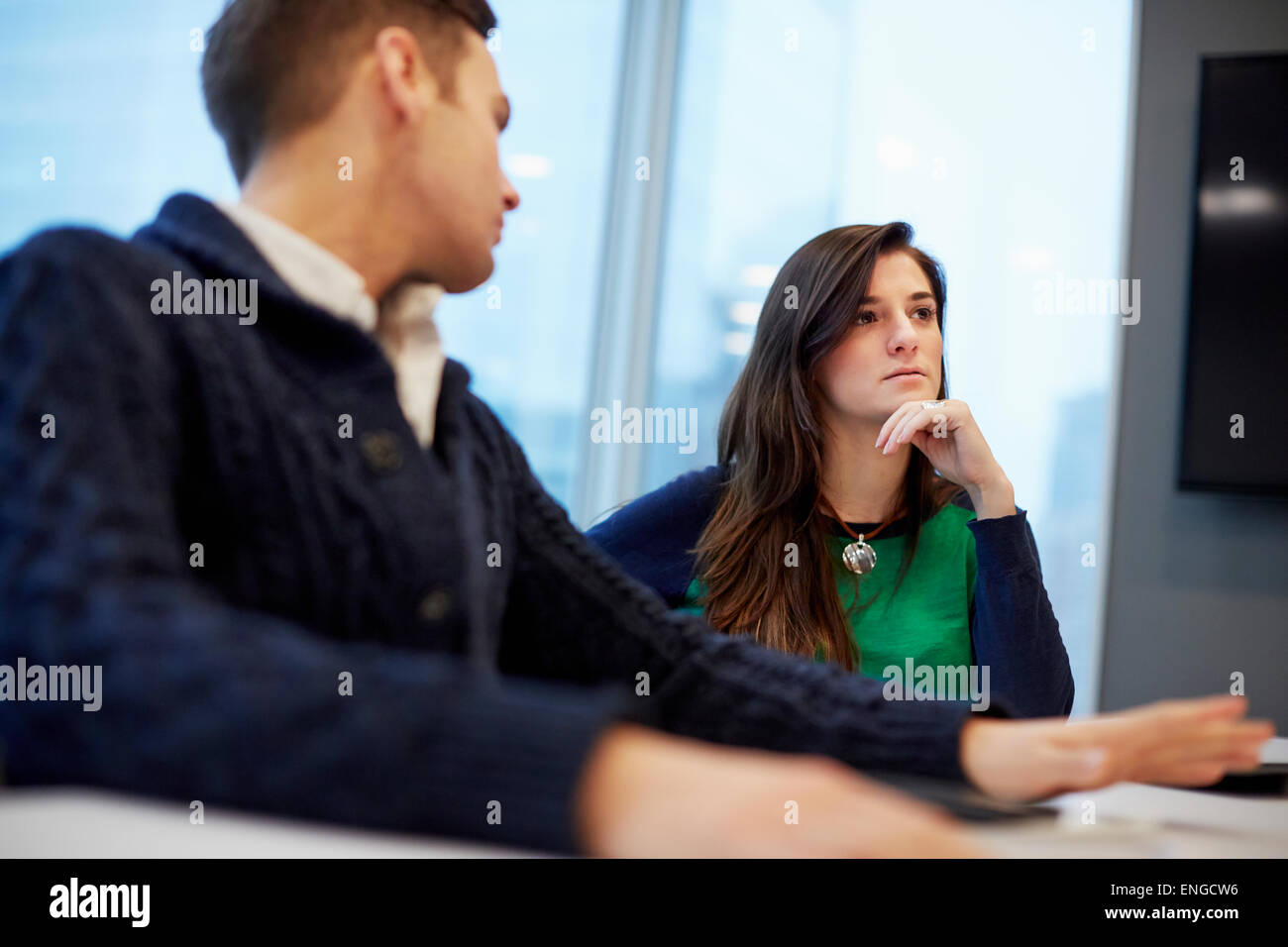 Un uomo e una donna seduti a una riunione in un ufficio. Foto Stock