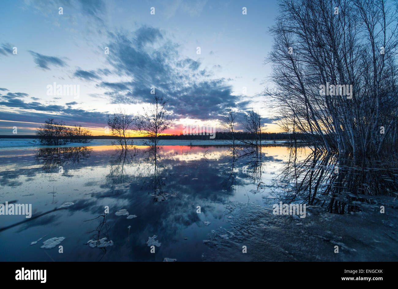 Un lago al tramonto. Fusione del ghiaccio sulla superficie dell'acqua. Foto Stock