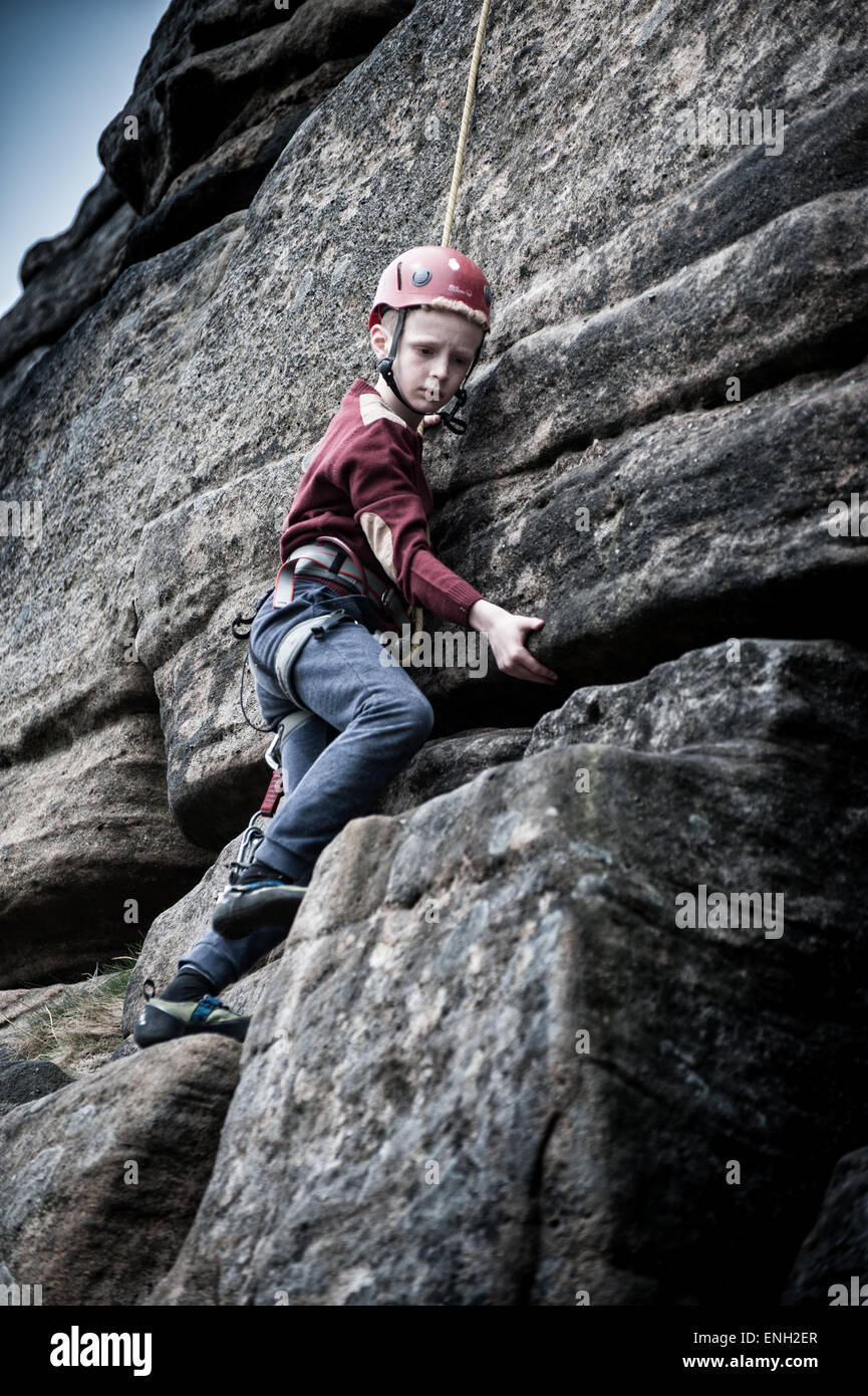 Un giovane ragazzo salendo a bordo Stanage nel Peak District Foto Stock