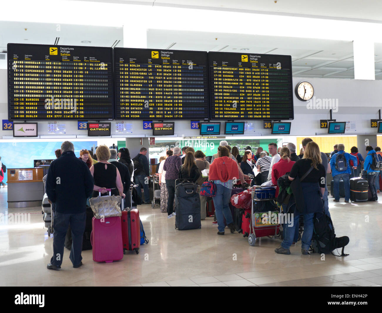 Aeroporto Spagna schermate informative e code di passeggeri e bagagli delle compagnie aeree aspettano sul atrio dell'aeroporto per effettuare il check-in al volo Foto Stock