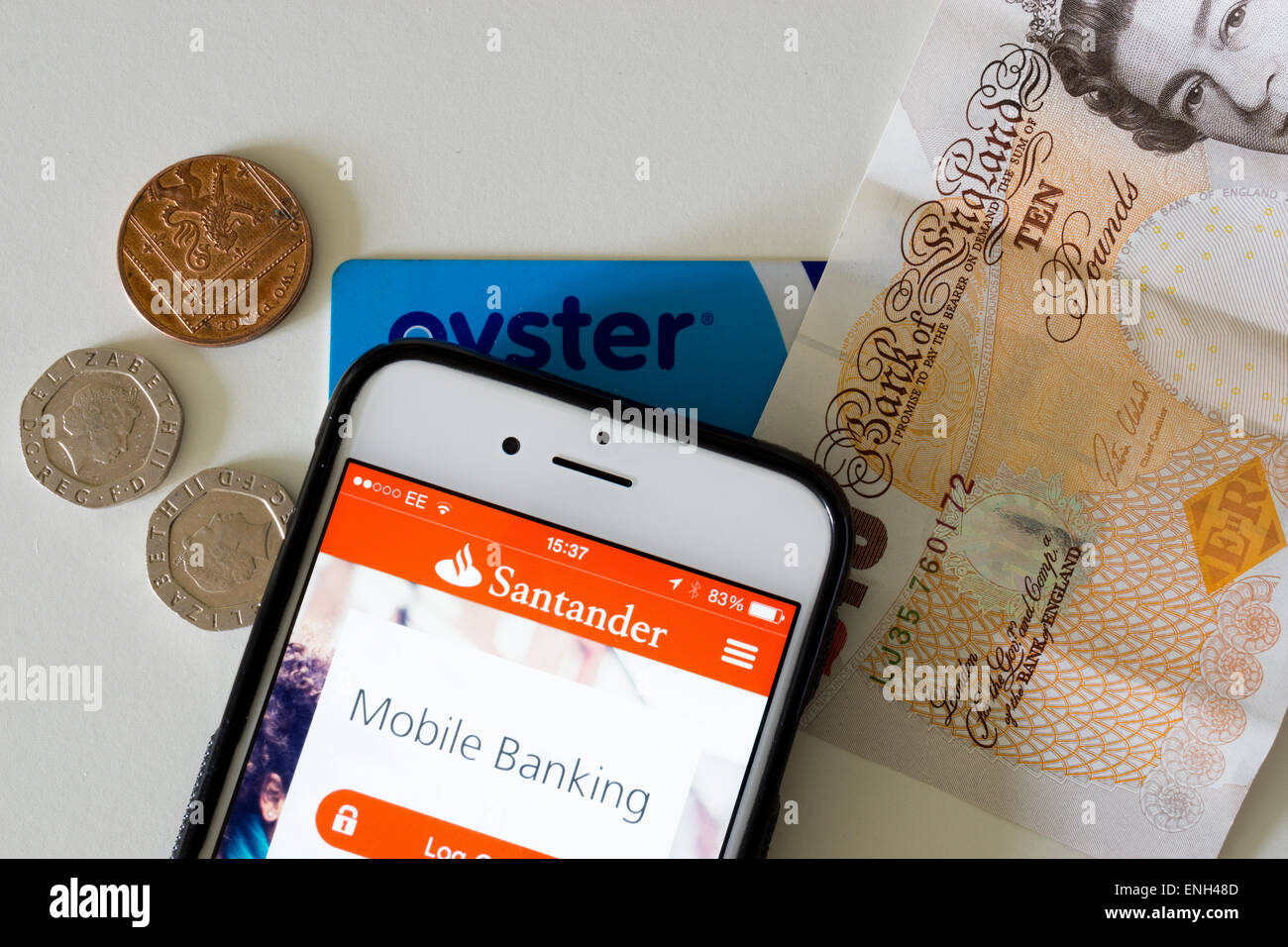 Moderni vari metodi di pagamento; contanti, un pagamento contactless card e mobile banking app visualizzata su un iPhone 6. Foto Stock