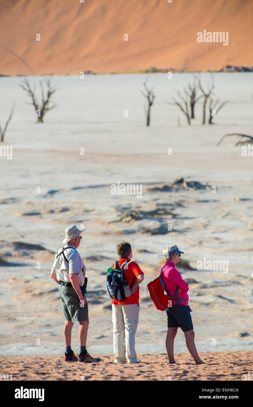 Africa, Namibia. Deserto del Namib. Sossusvlei, Naukluft Park. Deadvlei e gli alberi morti. Gli escursionisti sul lago essiccato. Modello rilasciato. Foto Stock