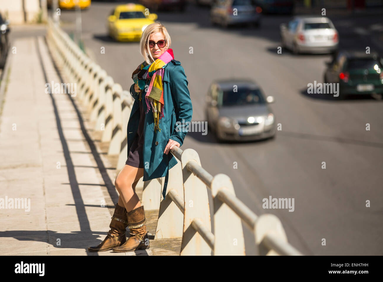 Giovane donna in piedi vicino a una strada trafficata. Foto Stock