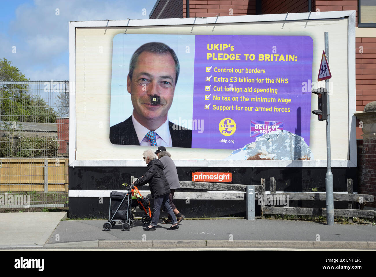 Su un UK Independence Party, 2015 cartellone elettorale un baffi neri è stata tracciata sulla foto del leader dell'UKIP Nigel Farage, a Portsmouth, Regno Unito.​ Foto Stock