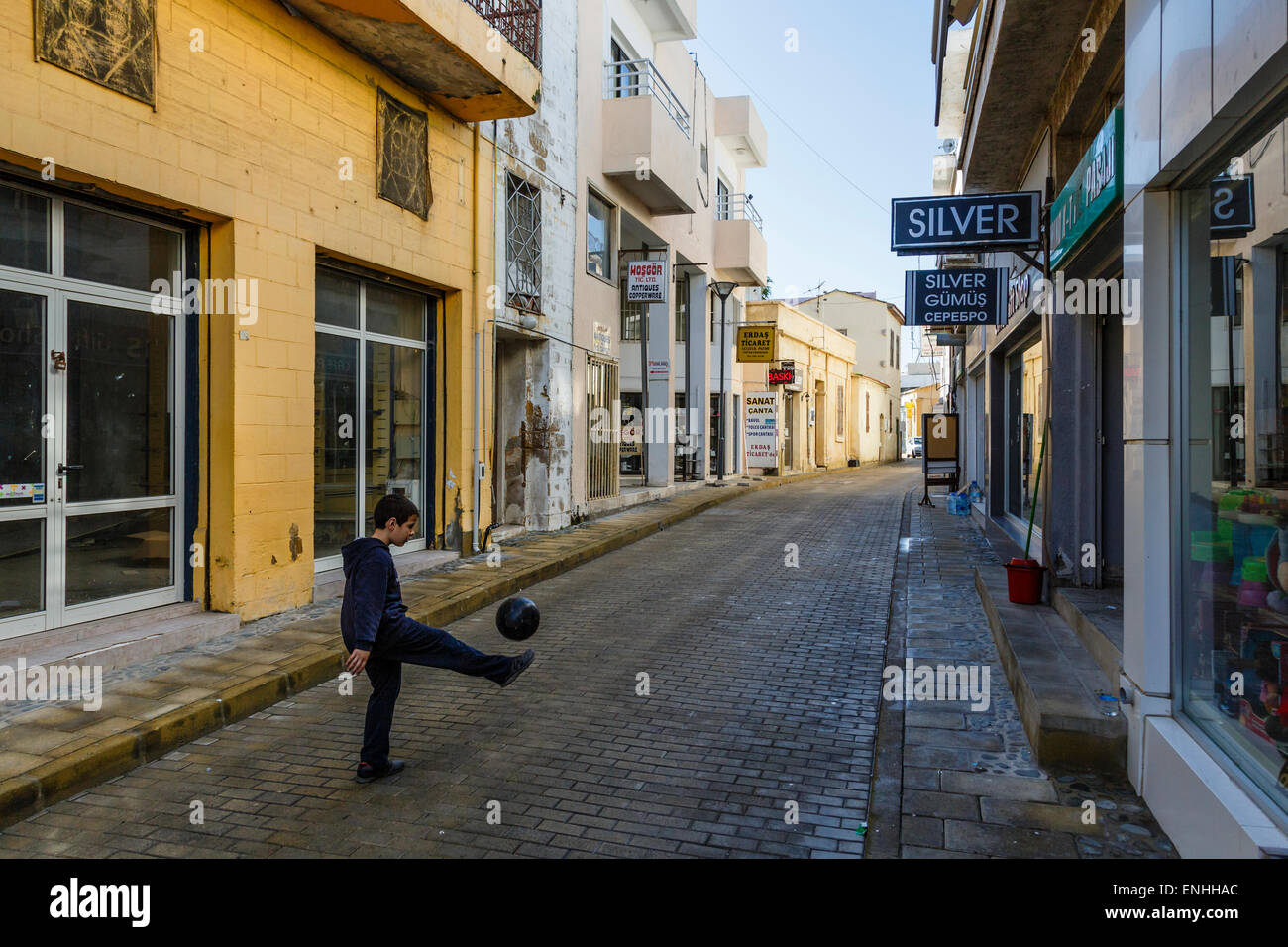 Ragazzo giocando a calcio nei vicoli di Gazimagusa (Famagusta), la parte settentrionale di Cipro. Foto Stock