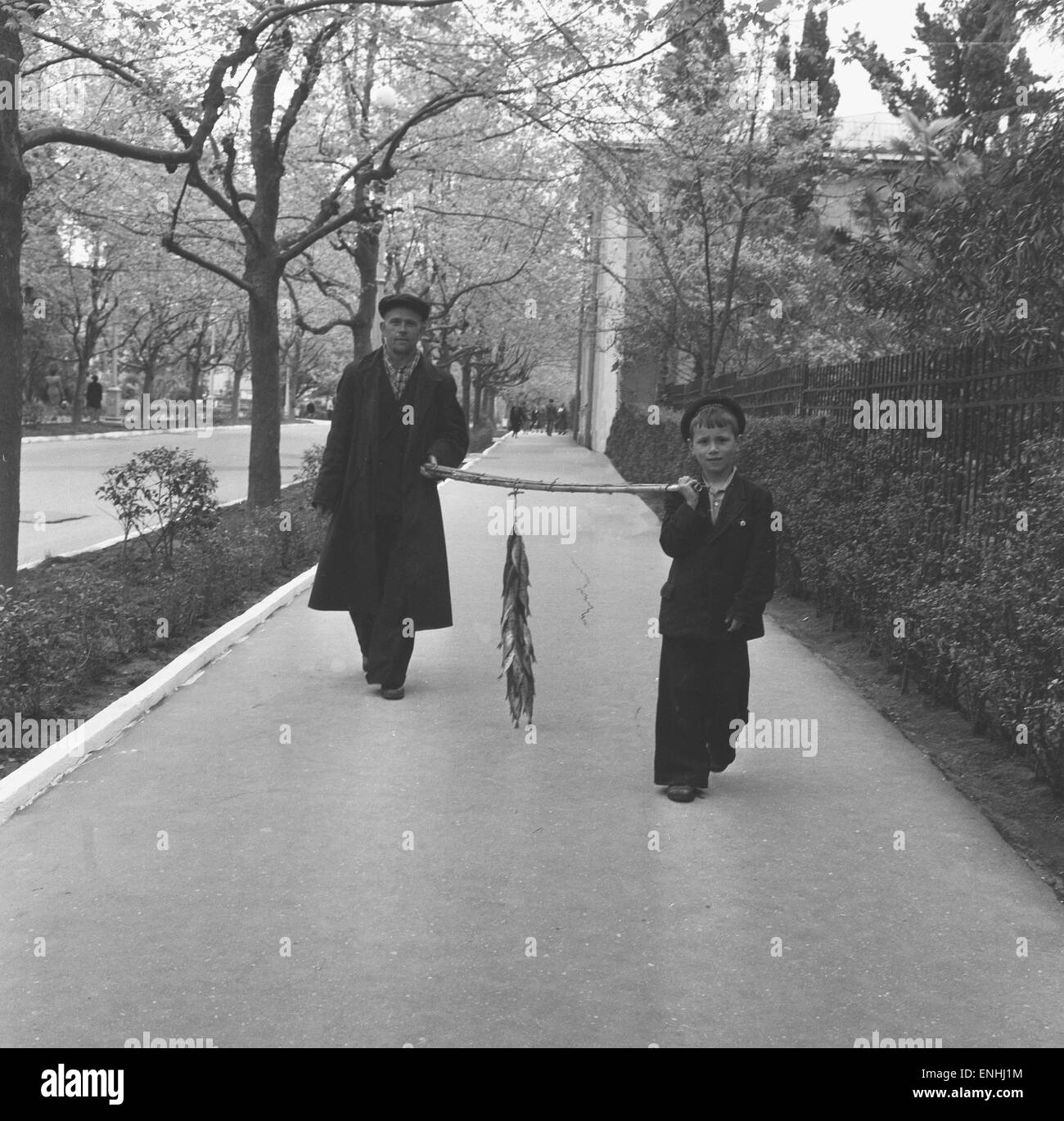 Padre e figlio si vede qui passeggiando per le strade di Mosca che trasportano le loro catture giornaliere dal fiume Moskva. 25 Maggio 1960 Foto Stock