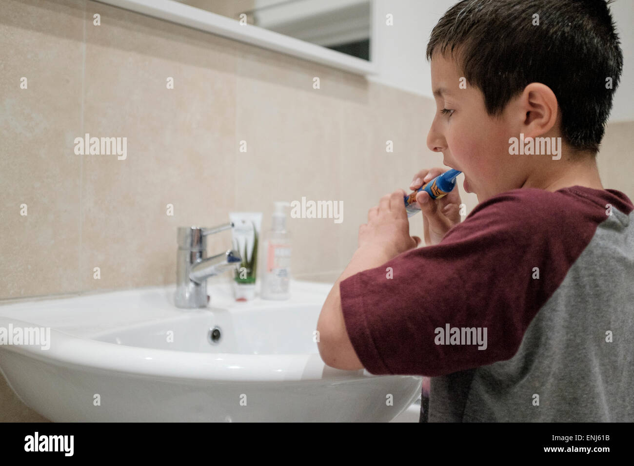 Ragazzo,7,spazzole i suoi denti prima di andare a letto Foto Stock