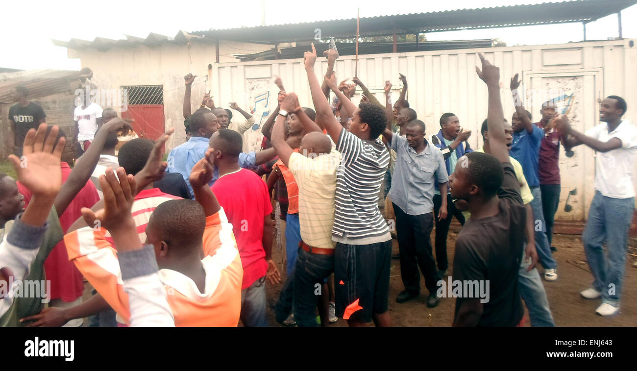 Una pistola sequestrati nelle mani, dimostranti presso Musaga (Burundi) jubilate dopo la perquisizione e il sequestro di una pistola da un civile sospettata di collaborare con i servizi segreti nazionali il 26 aprile 2015. Egli era nascosto tra i manifestanti a Musaga di vicinato e scampato alla morte grazie a soldati come manifestanti volevano ucciderlo. Foto: Apollinaire Niyirora/dpa Foto Stock