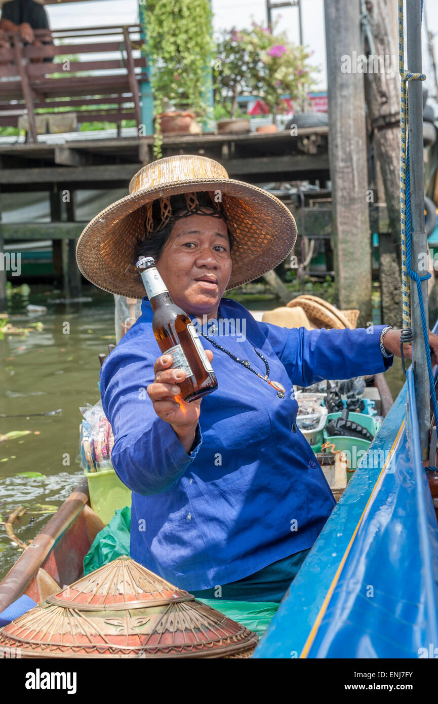 Imbarcazione locali fornitore che offre una bottiglia di birra. Bangkok. Della Thailandia Foto Stock