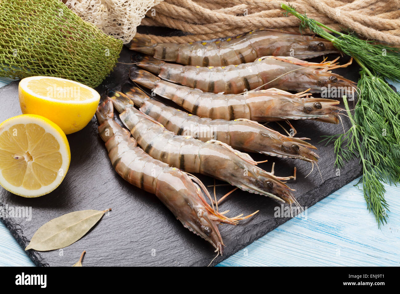 Crudo fresco gamberoni e attrezzature per la pesca sul tavolo di legno Foto Stock
