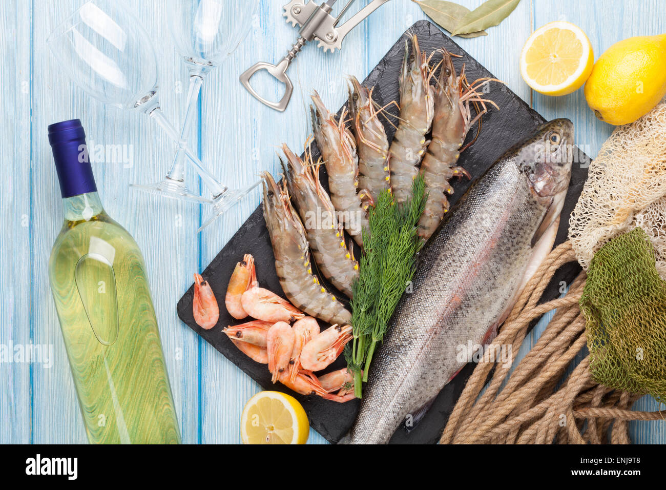Crudo fresco il cibo del mare con spezie e vino bianco bottiglia sul tavolo di legno dello sfondo. Vista superiore Foto Stock