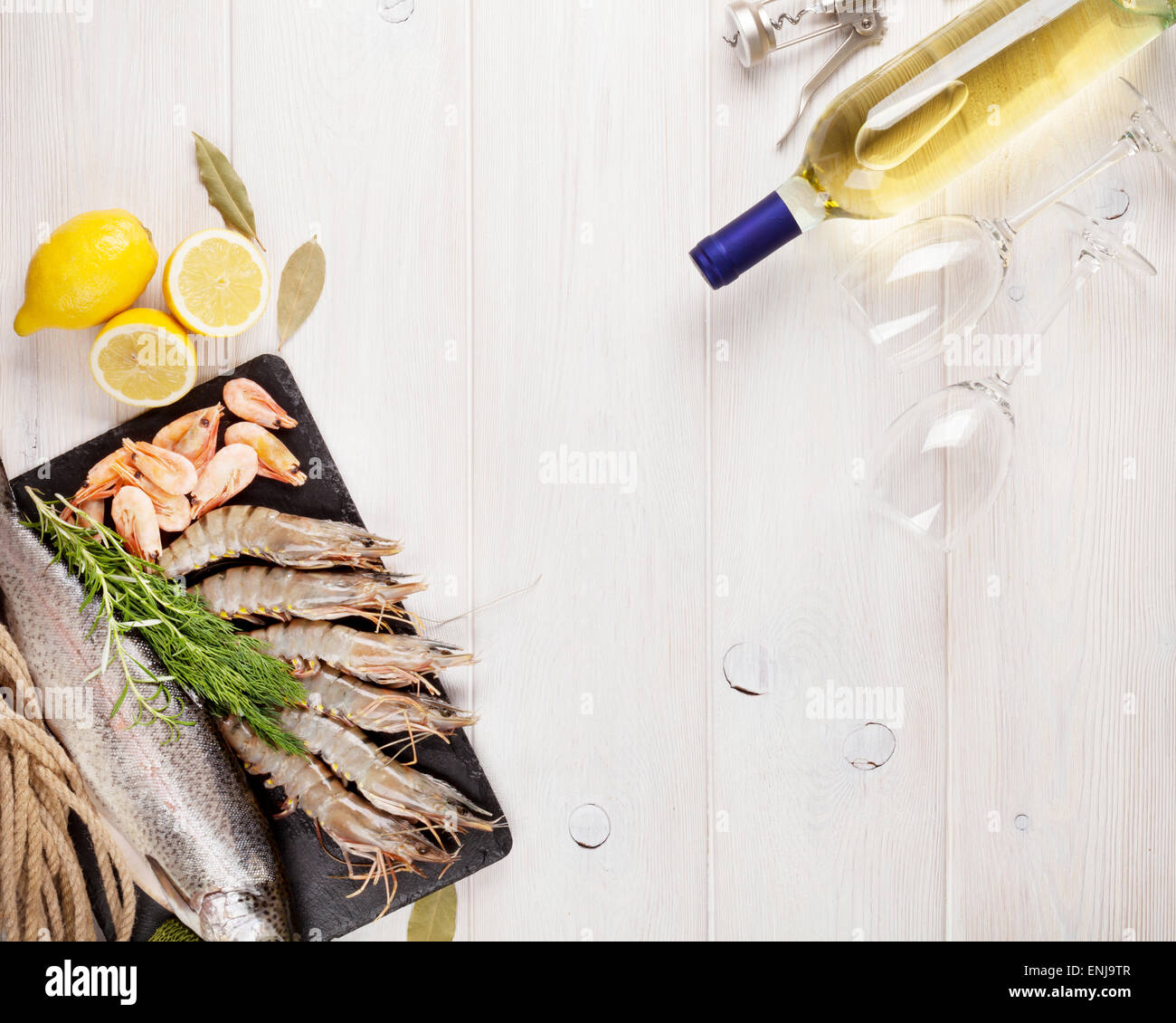 Crudo fresco il cibo del mare con spezie e vino bianco bottiglia sul tavolo di legno dello sfondo. Vista da sopra con lo spazio di copia Foto Stock