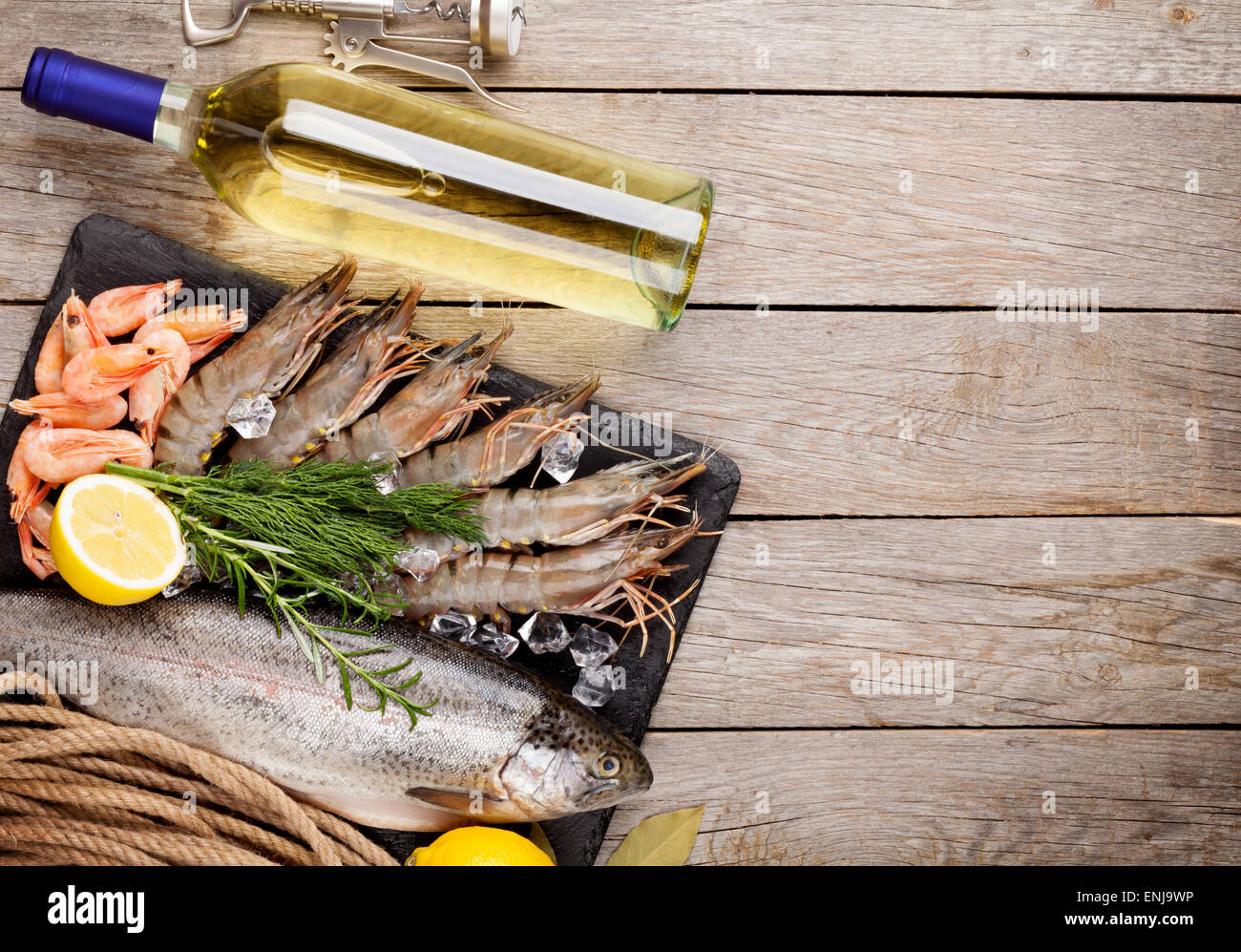 Crudo fresco il cibo del mare con spezie e vino bianco bottiglia sul tavolo di legno dello sfondo. Vista da sopra con lo spazio di copia Foto Stock